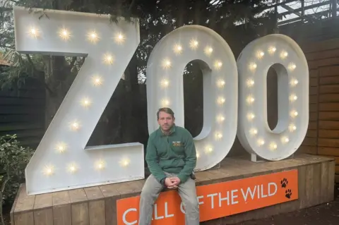 Ryan by a zoo sign