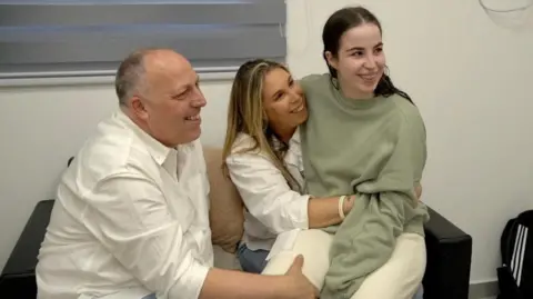 Reuters Agam Berger with her parents (30/01/25)