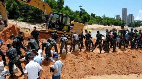 Barcroft Media/Getty Images Rescuers trying to pump water out of the tunnel