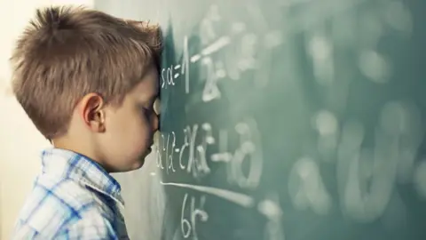 Imgorthand Young boy leans against chalkboard