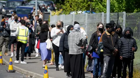 Getty Images People queue for Covid-19 vaccinations at the ESSA academy in Bolton where mass vaccinations are taking place to try and combat rising levels of the Indian coronavirus variant on May 18, 2021 in Bolton, England.