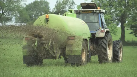 Getty Images/Andrew Linscott Tractor spreading slurry