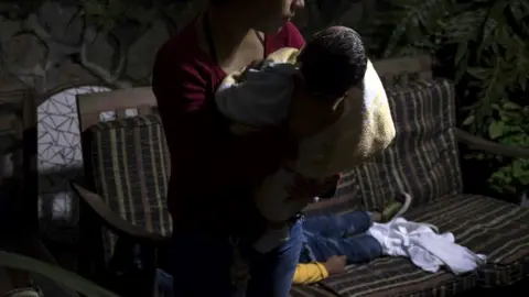 BBC / Oliver de Ros A woman holding a baby