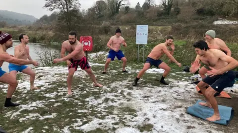 Group doing breathing exercises on snowy grass