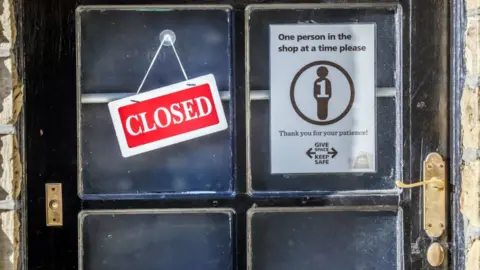 PA Media Signs on a shop in West Yorkshire