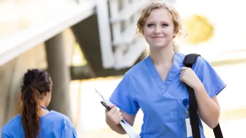 Getty Images Nurse walking and carrying bag