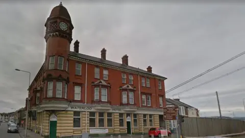Google A photo of the Waterloo Hotel in Newport - which is a three storey red bricked building. The photo is taken an overcast day