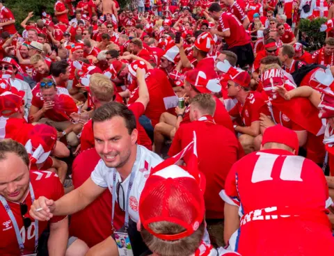 Peter Dench Danish fans drink beer and sing in central Moscow