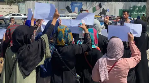 EPA Afghan women hold placards as they call on the Taliban to preserve their rights to work and an education, in Kabul, on 3 September 2021