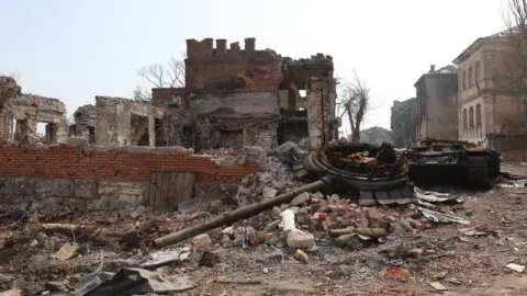 Anadolu Agency via Getty Images Destroyed buildings and a tank in Mariupol, Ukraine. Photo: 9 April 2022