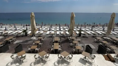 Reuters Tables and deckchairs are set out to respect social distancing on the Promenade des Anglais in Nice