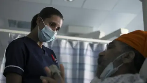 A nurse treating a patient at UHB