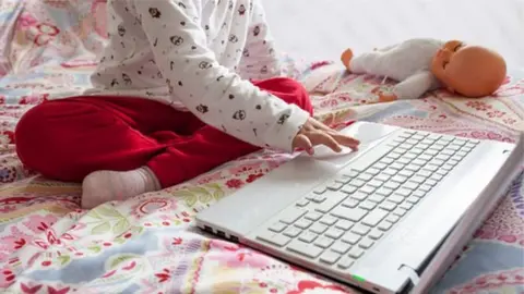 Getty Images child with laptopon bed