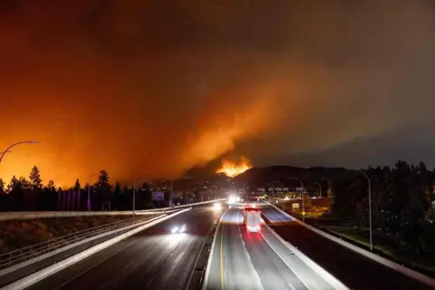 Getty Images The McDougall Creek wildfire burns in the hills of West Kelowna