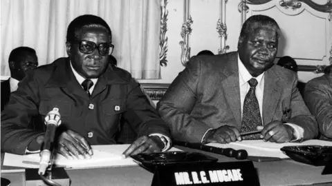 Getty Images The Constitutional Conference on the future of Zimbabwe-Rhodesia, attended by Robert Mugabe (L) and Joshua Nkomo (R). 10th September 1979: The Constitutional Conference on the future of Zimbabwe-Rhodesia, attended by Leaders of the Patriotic Front Robert Mugabe (left) and Joshua Nkomo at Lancaster House, London.