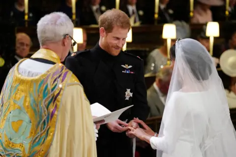 Reuters Prince Harry places the wedding ring on the finger of Meghan Markle in St George's Chapel