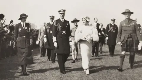 Getty/Science & Society Picture Library NORTHERN IRELAND - DECEMBER 11: A photograph of the visit of King George VI (1895-1952) and Queen Elizabeth (1900-2002), taken by an unknown photographer in 1937. This photograph is from an album compiled by Kodak Limited to record the coronation of George VI and Queen Elizabeth on 12 May 1937. George VI was the second son of George V and Mary of Teck. In 1923 he married Lady Elizabeth Bowes-Lyon, who bore him two daughters, Elizabeth (Queen Elizabeth II) and Margaret. He died from cancer on 6 February, 1952. (Photo by SSPL/Getty Images)