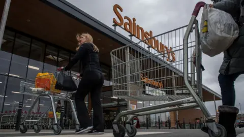 Getty Images People walk into Sainsbury's store