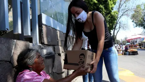 Reuters Woman hands out food parcels on behalf of the clothing company owned by El Chapo Guzman's daughter