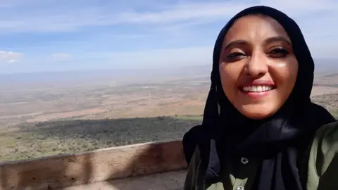 Fazeela Mubarak Activist Fazeela Mubarak poses for a photo against a forested backdrop