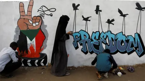 Reuters Demonstrators in Khartoum paint a mural reading "Freedom", 14 April 2019