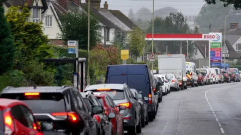 PA Media Motorists queuing for fuel at an Esso petrol station