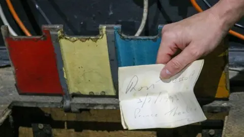 Princes Theatre, Clacton Red, yellow and blue trapdoor on hinges and note with handwriting