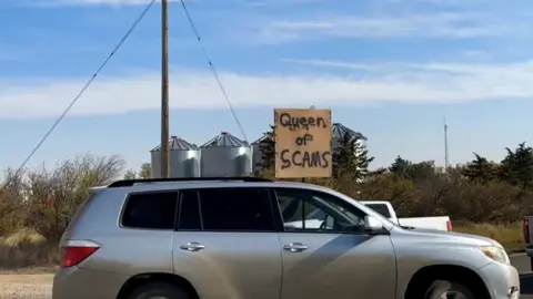 Community TV / ComTV.ca Part of Sunday's protest against the camp inside the school. A sign reads "Queen of Scams"