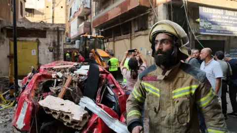 Reuters A firefighter works at the site of an Israeli strike that the Israeli military says killed a senior Hezbollah commander, in Beirut's southern suburbs, Lebanon (24 September 2024)