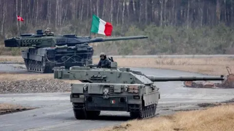 A Denmark's Leopard 2 tank (back) and Italy's Ariete tank take part in the 'US Army Europe and Africa International Tank Challenge' exercise at the military training area in Grafenwoehr, Germany, 11 February 2025. 