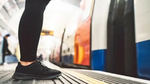 Getty Images Woman waits for train