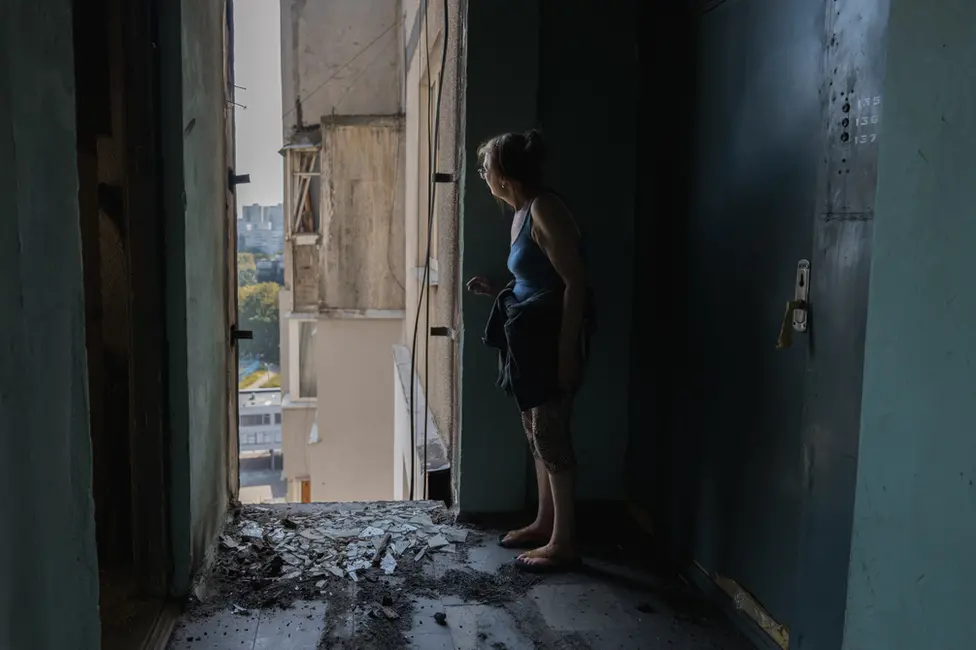 BBC Larisa looks out from her hallway on the 16th floor. She is worried the building will collapse