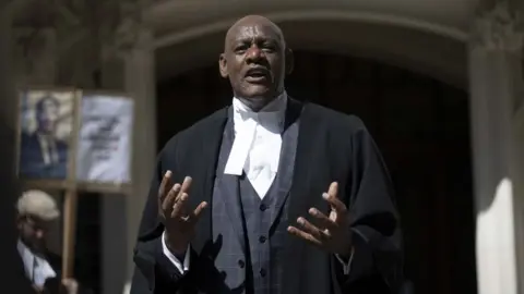 Getty Images Shaun Wallace, a barrister known to many as a TV quizzer on The Chase, speaking the picket line outside the Royal Courts of Justice in July