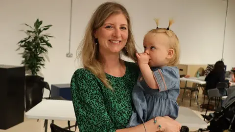 Naoise Muldoon holding daughter