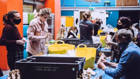 Ocean Conservation Trust Volunteers bagging seagrass seeds