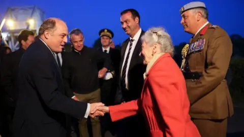 Getty Images Defence secretary Ben Wallace shakes hands with Arlette Gondree