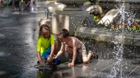 Getty Images LONDON, ENGLAND - JUNE 23: Children play in a fountain in Leicester Square on June 23, 2026 in London, England. 