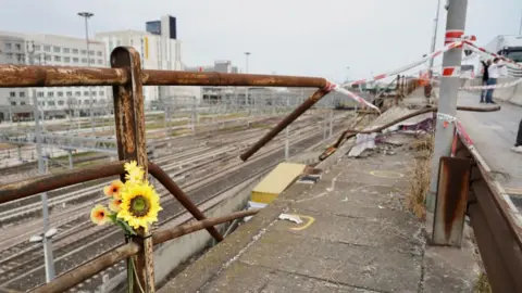 Flowers left by the overpass where the bus crashed on Tuesday evening
