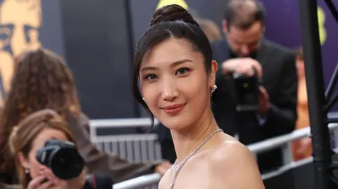 Getty Images Singer Ejae poses for pictures on a red carpet event 