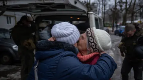 Anadolu Agency via Getty Images Elderly women hug after evacuation from Kupiansk, north-eastern Ukraine. Photo: 27 February 2023