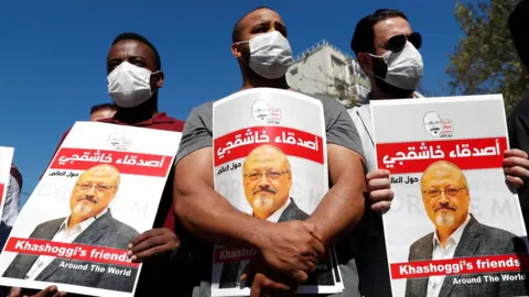 Reuters Men hold up posters of Saudi journalist Jamal Khashoggi on the second anniversary of his killing, outside the Saudi consulate in Istanbul, Turkey (2 October 2020)