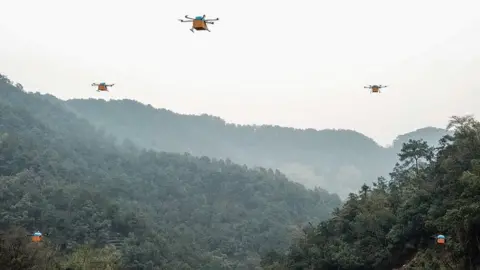 Getty Images A fleet of drones transport tea leaves over mountainous Zhejiang Province in China