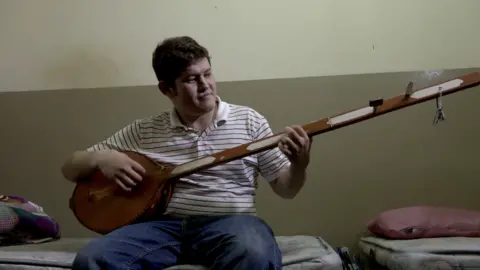 Mujtaba Hossain playing a traditional instrument