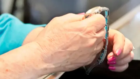 Getty Images Elderly woman holding a watch