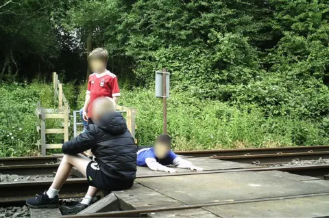 Network Rail Children on level crossing in Wing