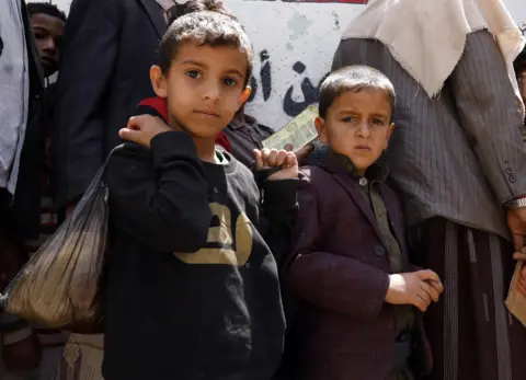 EPA Yemeni children wait to get free food rations from a charity group in Sanaa, April 2020