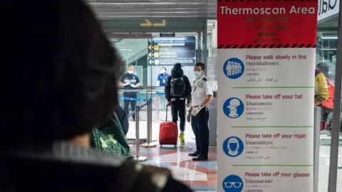 Getty Images Public Health Officials run thermal scans on passengers arriving from Wuhan, China at Suvarnabumi Airport on January 8, 2020 in Bangkok, Thailand