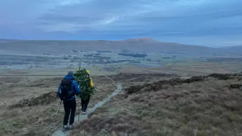 ED JACKSON Ross Stirling and Ed Jackson climbing a mountain. You can see them from behind.