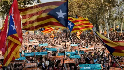 AFP Pro-independence supporters wave flags outside the Catalan regional parliament