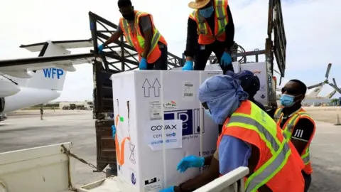 Reuters Workers offload AstraZeneca/Oxford vaccines under the COVAX scheme at the Aden Abdulle Osman Airport in Mogadishu, Somalia